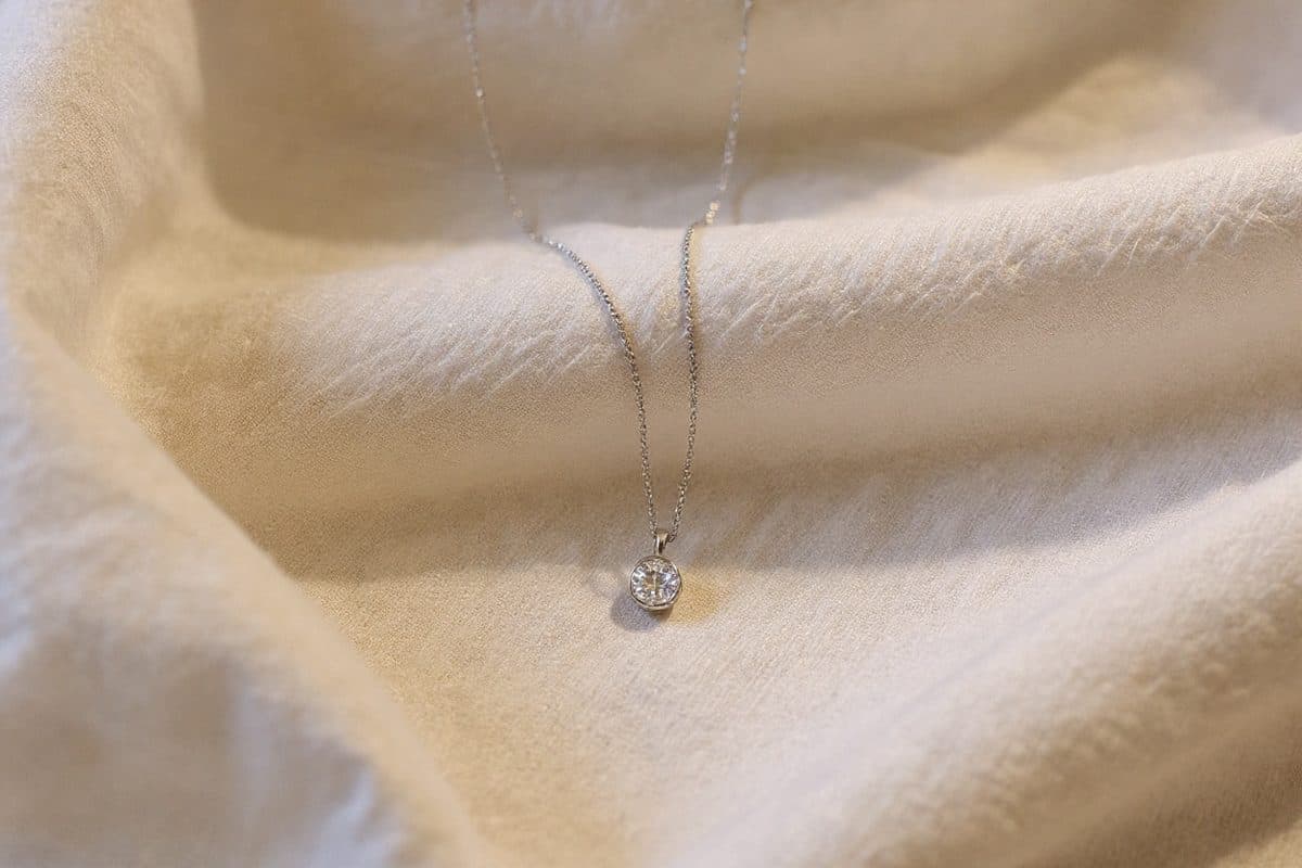 Eira, Minimal jewellery composition on a clean surface, soft reflection, premium finish